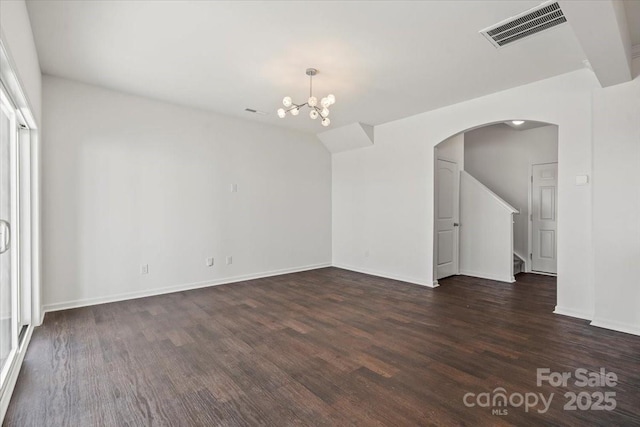 unfurnished room with baseboards, visible vents, arched walkways, dark wood-style floors, and a notable chandelier