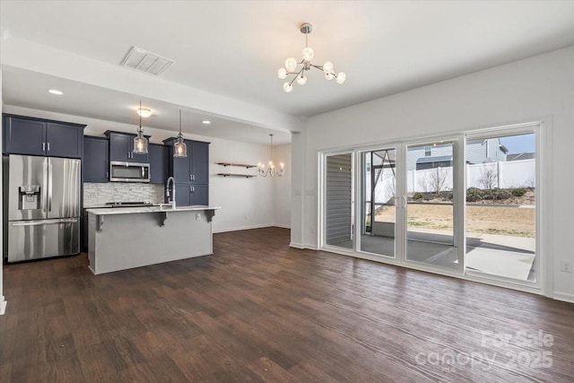 kitchen with stainless steel appliances, a breakfast bar, light countertops, and an inviting chandelier