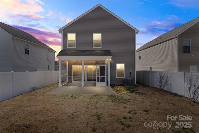 back of house with central AC, a lawn, a fenced backyard, and a sunroom