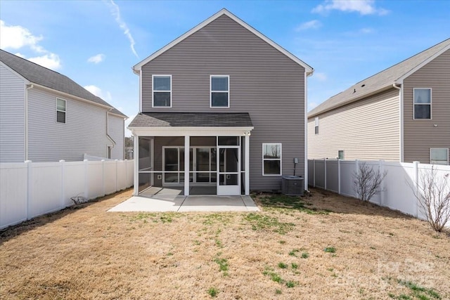 rear view of house with a sunroom, a fenced backyard, a lawn, and a patio