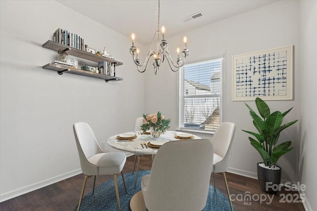 dining area featuring an inviting chandelier, baseboards, wood finished floors, and visible vents