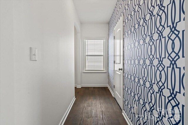 hall featuring baseboards and dark wood finished floors