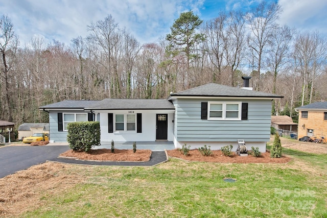 view of front of home featuring aphalt driveway and a front yard