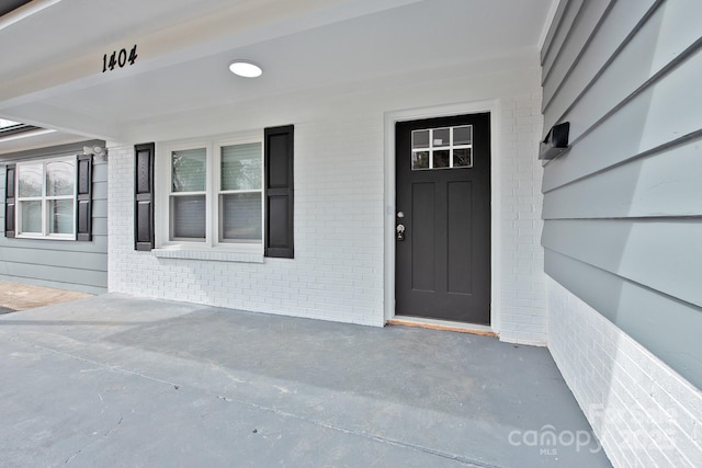 doorway to property with brick siding