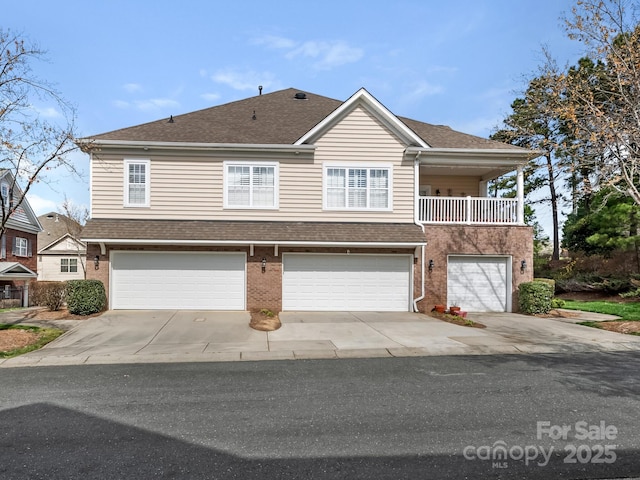 view of front facade featuring driveway, brick siding, roof with shingles, and an attached garage