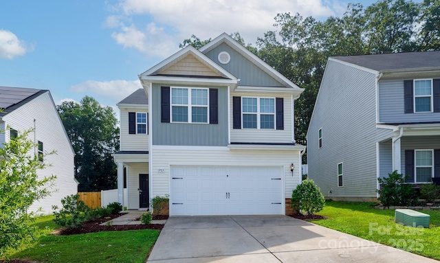 view of front of property with an attached garage, fence, concrete driveway, board and batten siding, and a front yard