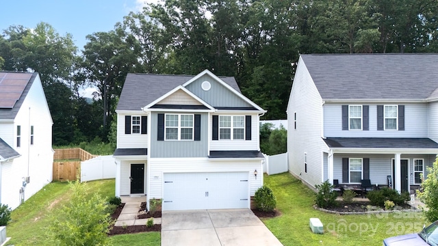 view of front of home featuring an attached garage, driveway, a front yard, and fence