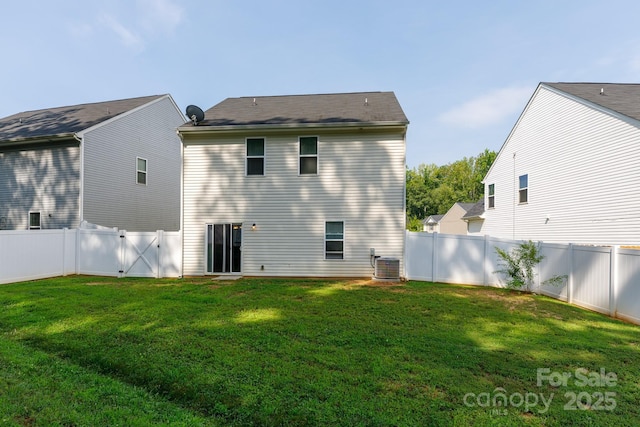 rear view of property with cooling unit, a gate, a fenced backyard, and a yard