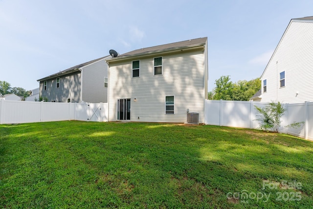 rear view of house featuring a fenced backyard, a lawn, and central AC unit