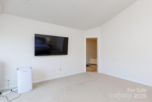 unfurnished living room featuring vaulted ceiling, carpet flooring, and baseboards