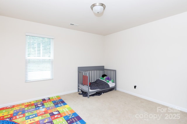 carpeted bedroom with visible vents and baseboards