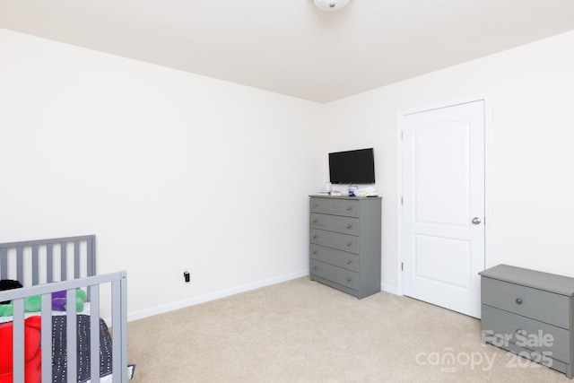 bedroom featuring light carpet and baseboards