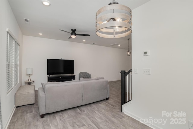 living room featuring light wood-style flooring, visible vents, baseboards, and recessed lighting