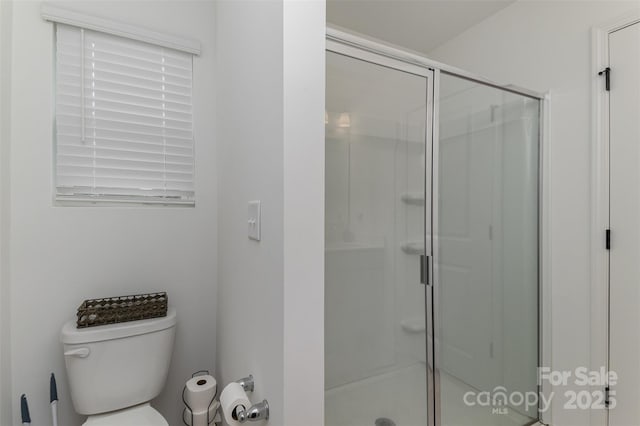 full bath featuring a shower stall and toilet