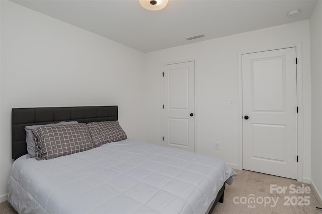 carpeted bedroom featuring visible vents and baseboards