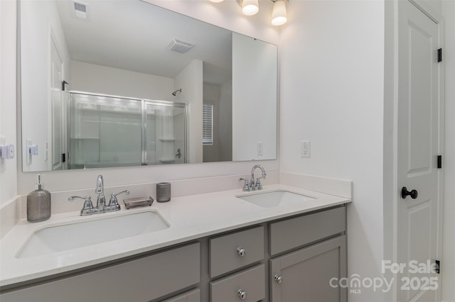 full bathroom featuring visible vents, a sink, and a shower stall