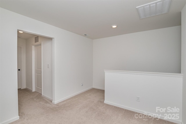 spare room featuring light carpet, baseboards, and visible vents