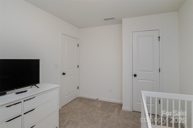 bedroom with visible vents, light carpet, and baseboards