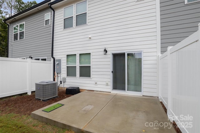 rear view of property featuring a patio, fence, and central air condition unit