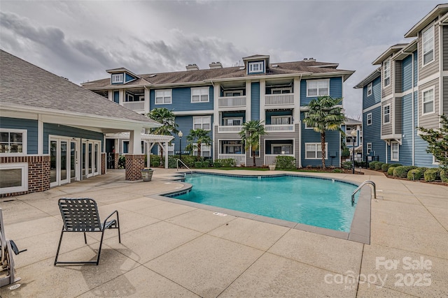 pool with a patio area and a residential view