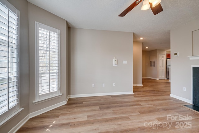 spare room featuring ceiling fan, a textured ceiling, recessed lighting, baseboards, and light wood finished floors