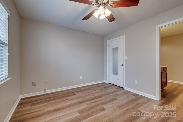 unfurnished bedroom with baseboards, a ceiling fan, and light wood-style floors