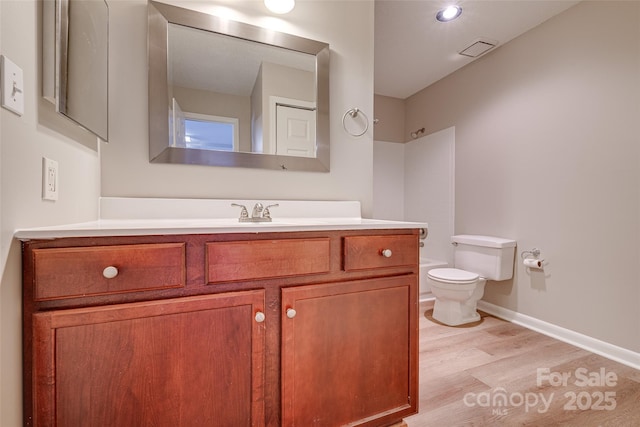 full bath with visible vents, toilet, vanity, wood finished floors, and baseboards