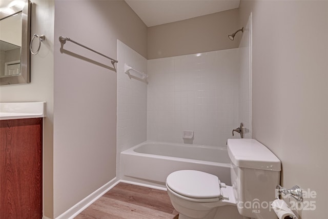 bathroom featuring bathtub / shower combination, toilet, vanity, wood finished floors, and baseboards