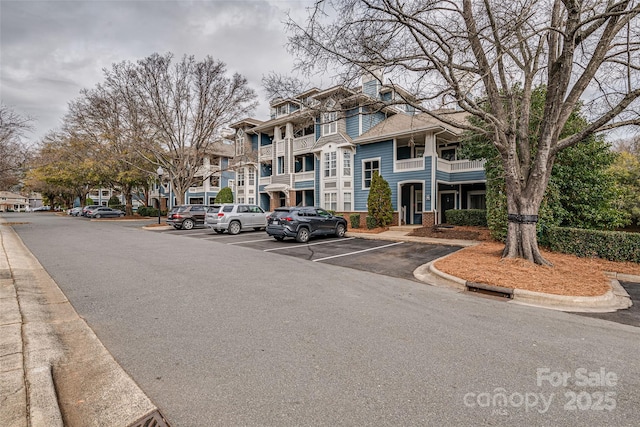 view of property featuring uncovered parking and a residential view