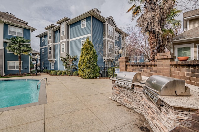 community pool featuring a patio area, area for grilling, and a grill