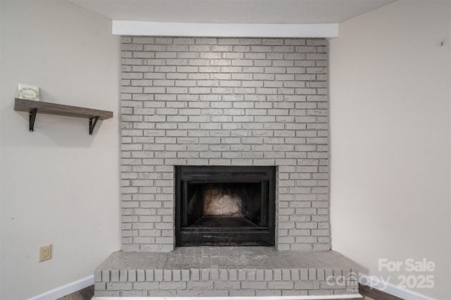 interior details featuring a brick fireplace and baseboards