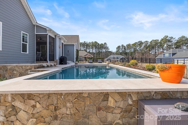 view of swimming pool featuring a patio, a ceiling fan, fence, a fenced in pool, and grilling area