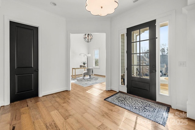 entryway featuring a notable chandelier, light wood-style flooring, visible vents, and baseboards