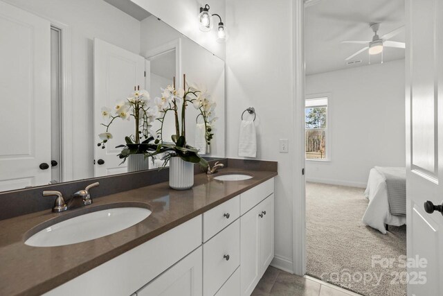 full bath with a sink, a ceiling fan, double vanity, and ensuite bathroom