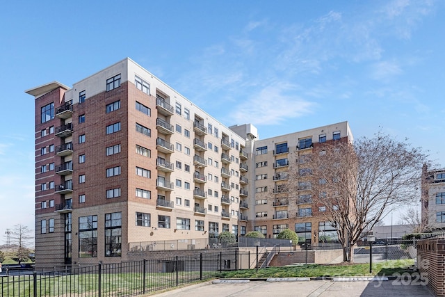 view of property featuring uncovered parking and fence