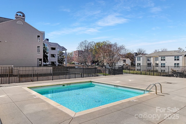 pool featuring a patio area, fence, and a residential view