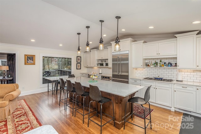 kitchen featuring white cabinets, a breakfast bar area, stainless steel appliances, and light countertops