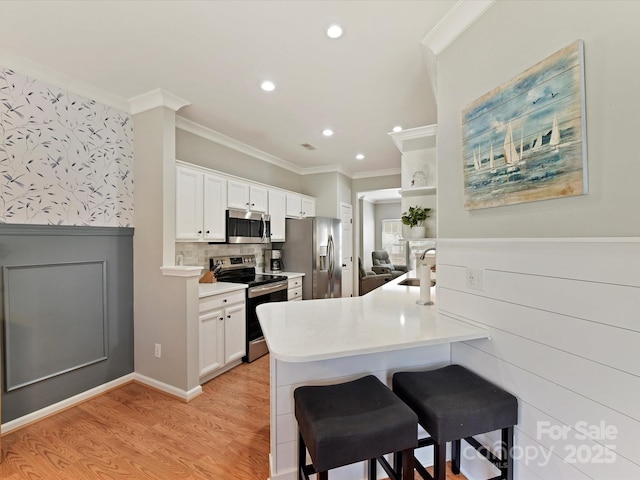 kitchen featuring stainless steel appliances, a peninsula, open shelves, a kitchen bar, and crown molding