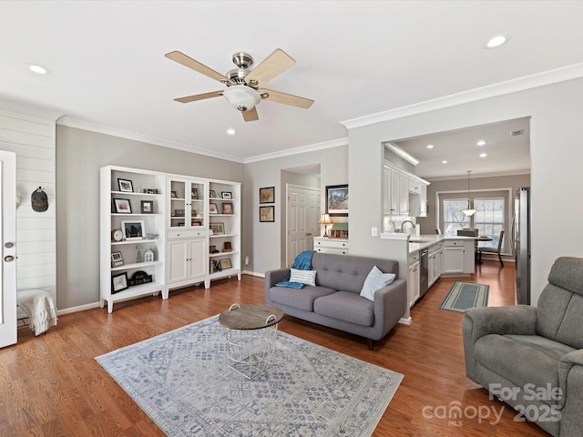 living area with dark wood-style flooring, recessed lighting, a ceiling fan, and crown molding