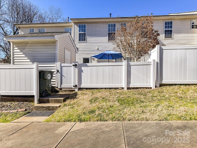 back of property featuring a gate and fence