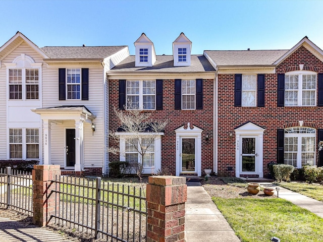 view of property with a fenced front yard and brick siding