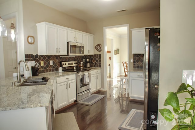 kitchen with white cabinetry, stainless steel appliances, dark wood-type flooring, and a sink