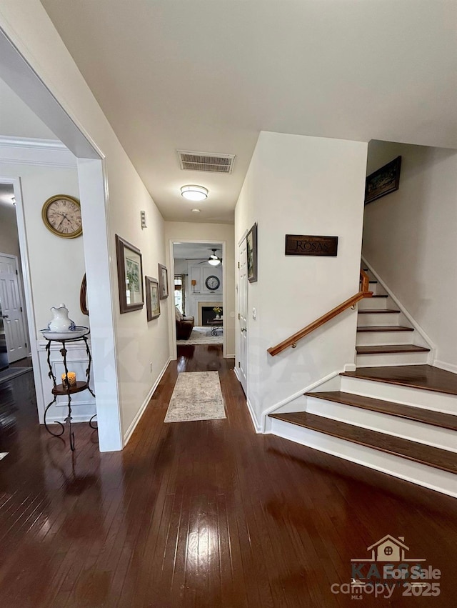 hall with visible vents, stairway, baseboards, and hardwood / wood-style floors