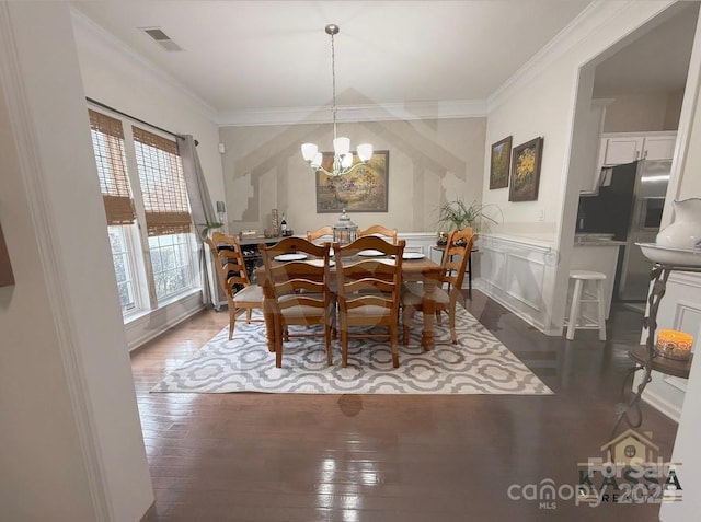 dining area with a decorative wall, visible vents, crown molding, and hardwood / wood-style floors