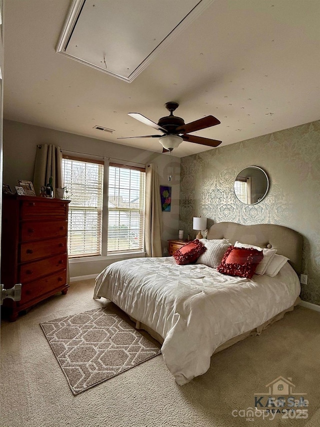 carpeted bedroom with visible vents, ceiling fan, attic access, and baseboards