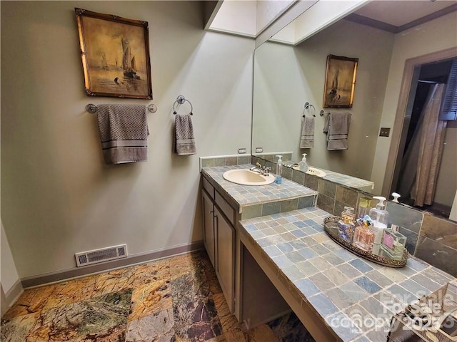 bathroom with visible vents, vanity, and baseboards