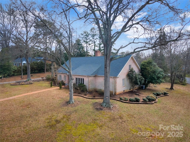 view of front of property featuring driveway, a chimney, and a front lawn