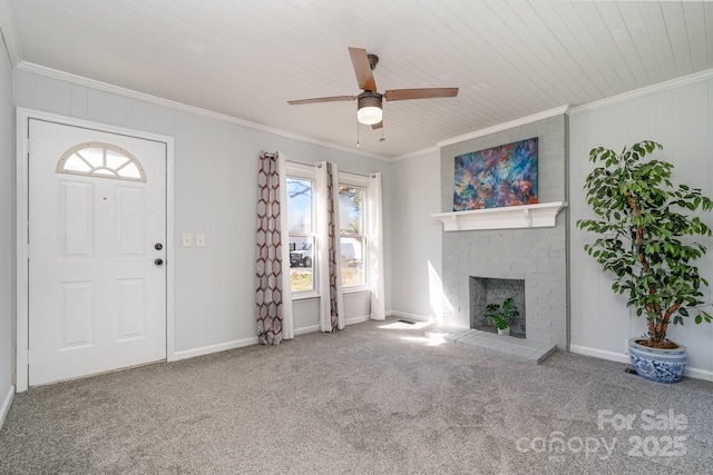 unfurnished living room featuring ornamental molding, a fireplace, baseboards, and carpet floors