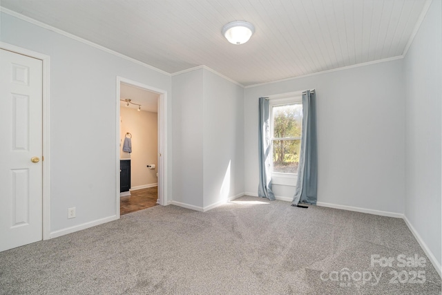 spare room featuring baseboards, carpet, and ornamental molding