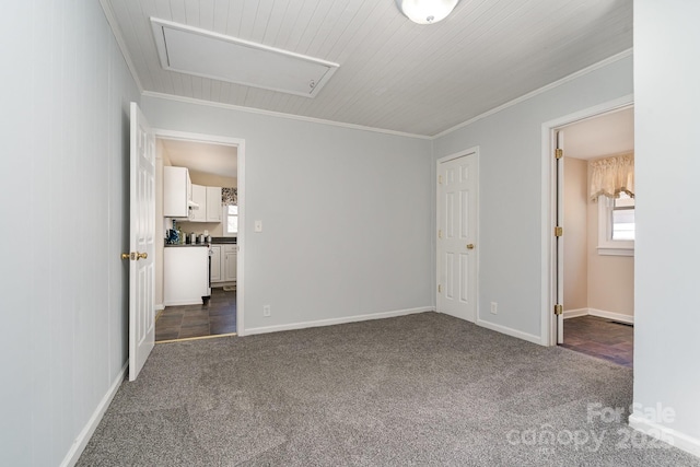 unfurnished bedroom with dark carpet, crown molding, and baseboards